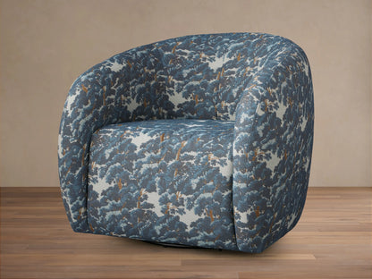 Rounded Fresno Swivel Chair upholstered in blue & brown "Oaks Pacific" tree pattern fabric, seen from front on a wooden floor.