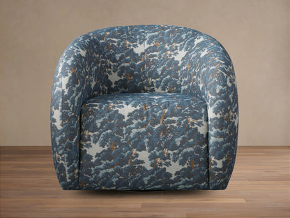 Rounded Fresno Swivel Chair upholstered in blue & brown "Oaks Pacific" tree pattern fabric, seen from front on a wooden floor.