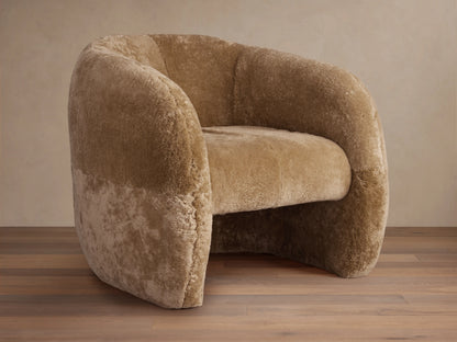 Fresno Shearling Floating Seat Chair in light brown shearling fabric. Features curved backrest and armrests with wooden floor.