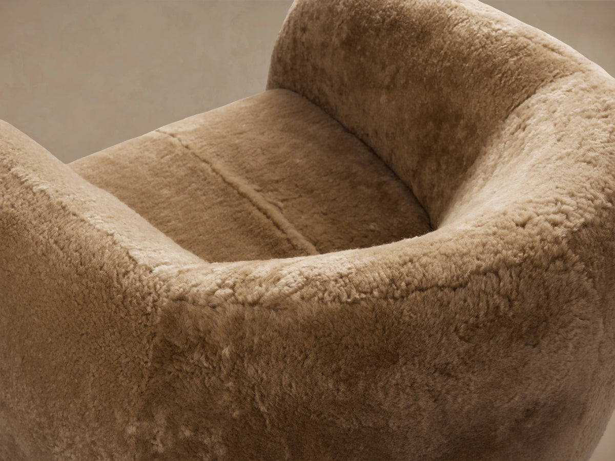 Fresno Shearling Floating Seat Chair in tan shearling fabric, featuring a rounded backrest and plush cushioning on a wooden floor.