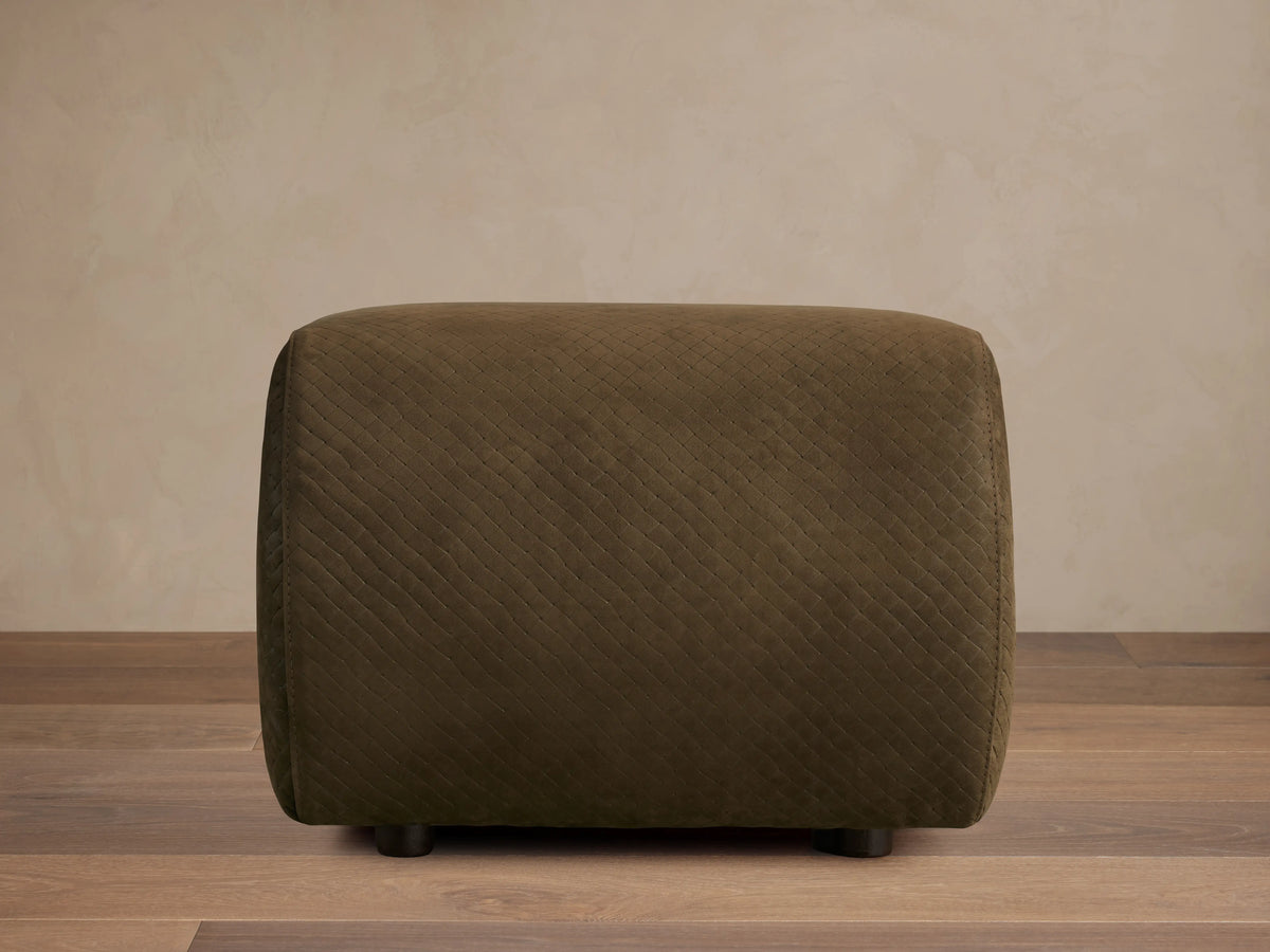 Front view of the dark olive green quilted Fresno Leather Ottoman with small dark feet.