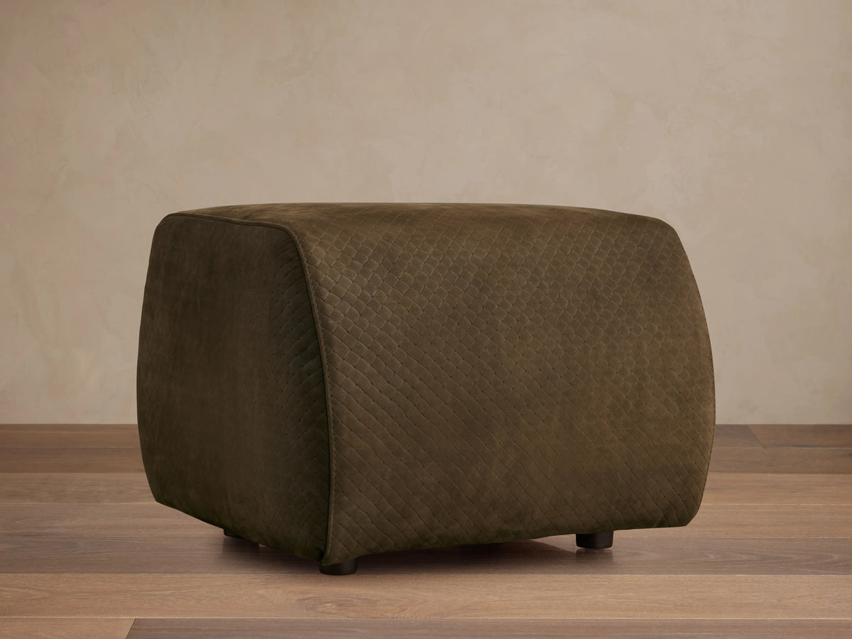 Front view of the dark olive green quilted Fresno Leather Ottoman with small dark feet.