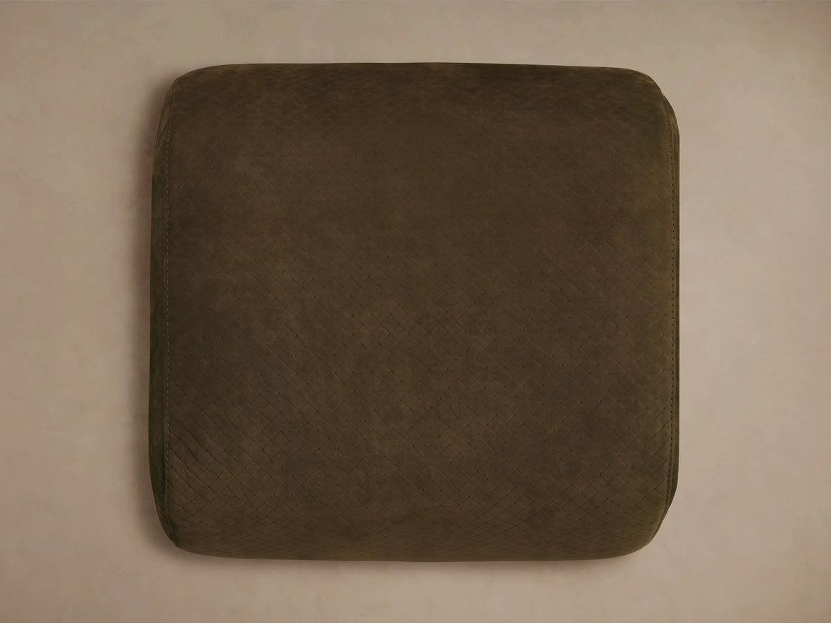 Close-up of the distressed brown embossed leather on the Fresno Leather Ottoman, showing a square pattern and light stitching.