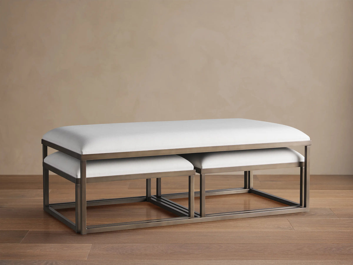 Palmer Upholstered Nesting Ottoman: Two white upholstered rectangular ottomans with bronze metal bases, one nested.
