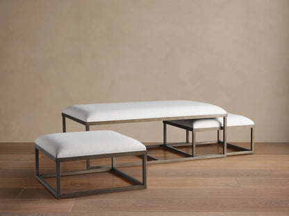 Palmer Upholstered Nesting Ottoman: Two white upholstered rectangular ottomans with bronze metal bases, one nested.