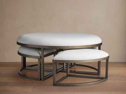 Palmer Upholstered Round Nesting Ottoman: large white top, dark metal base, smaller white ottomans nested beneath.