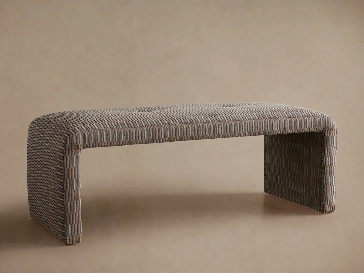 Ryan Bench: U-shaped, upholstered in a fabric with small vertical muted multi-tonal stripes, straight on view on a wooden floor.