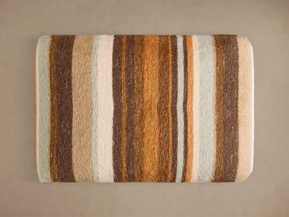 Front view of the Ryan Petite Ottoman upholstered in a striped pattern with brown, orange, cream, and pale blue.