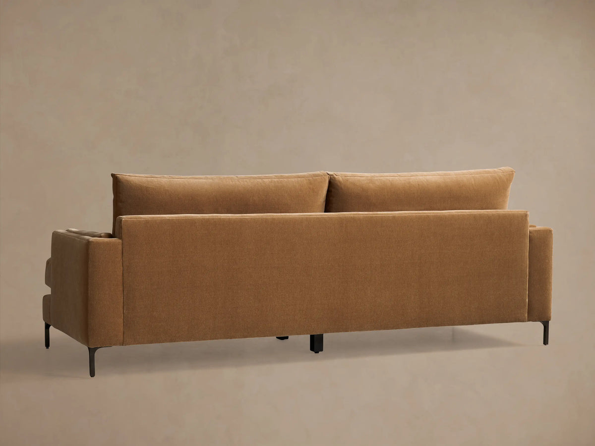 Close-up of the brown velvet Sofa, highlighting the thick, structured armrest, plush seat, and soft back cushion.