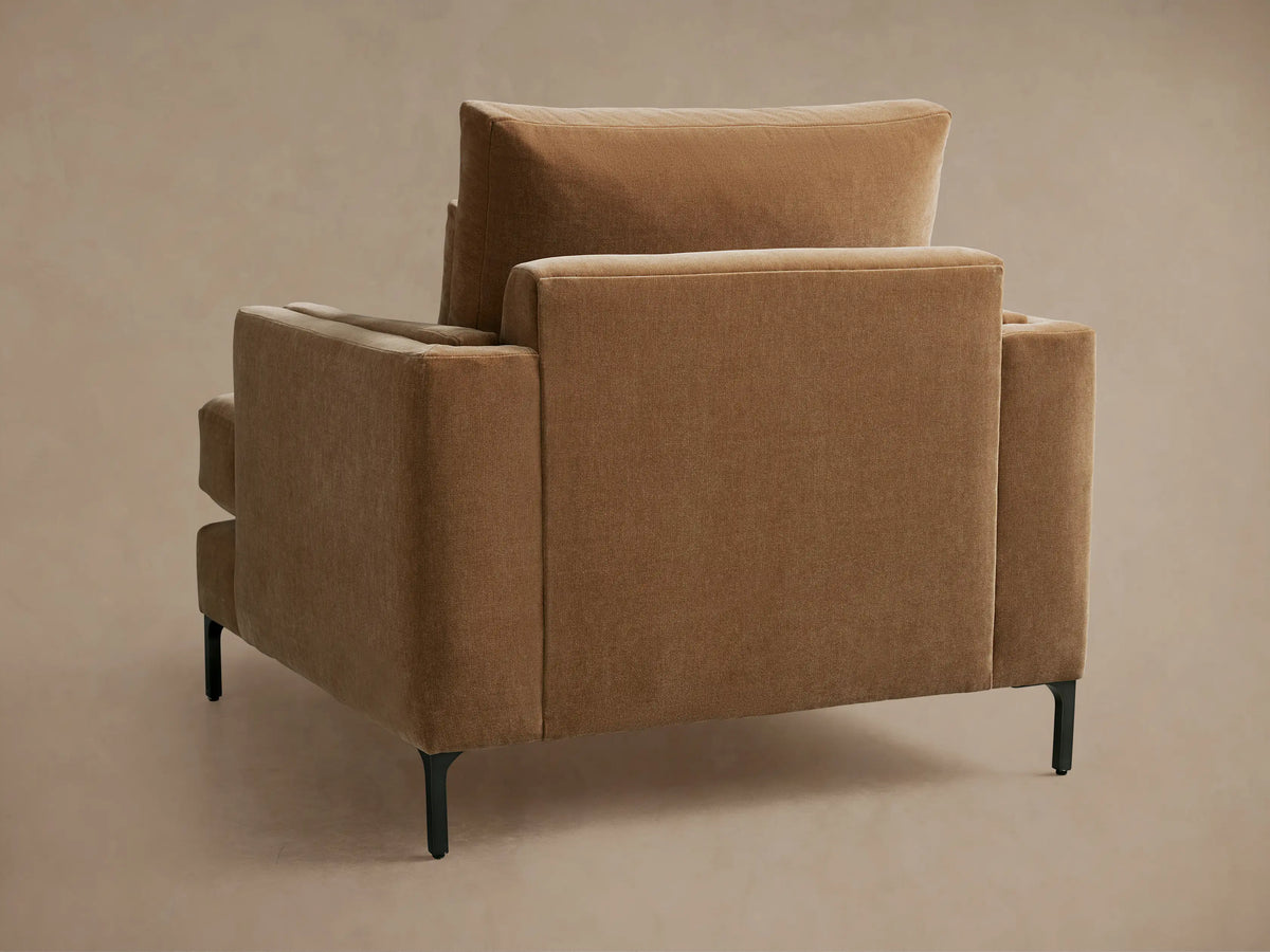Brown Sumner Chair close-up showing plush cushions and smooth fabric texture on seat and backrest with elegant armrest design.