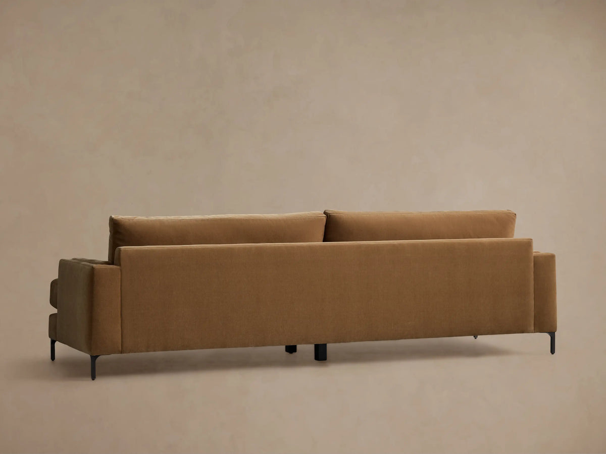 Rear view of the brown Sumner Sofa, showing its plush back cushions and slim black metal legs.