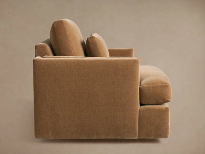 Sumner Swivel Chair in soft brown fabric, featuring a plush cushion and wide armrests. Close-up view highlights texture and comfort.