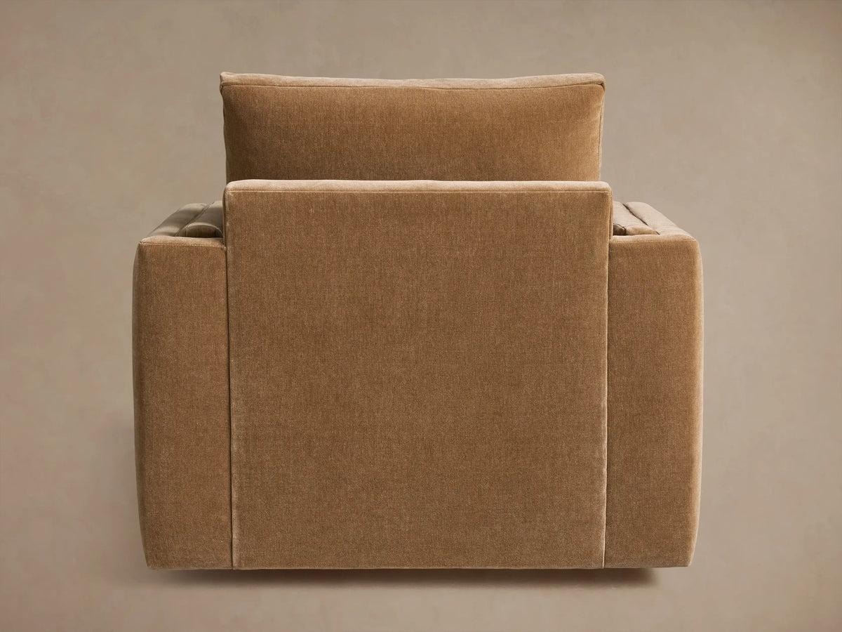 Sumner Swivel Chair in neutral brown fabric, showing the back and side views. Features boxy cushions and a solid swivel base.