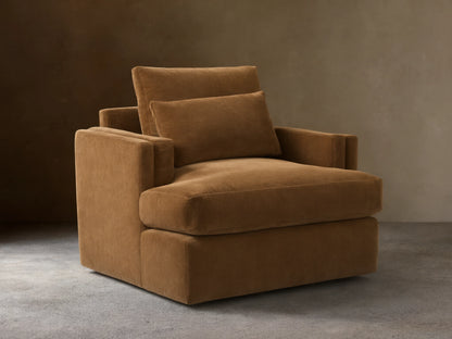 Sumner Swivel Chair in brown fabric, featuring a plush seat cushion, two padded back cushions, and solid square armrests on a hardwood floor.