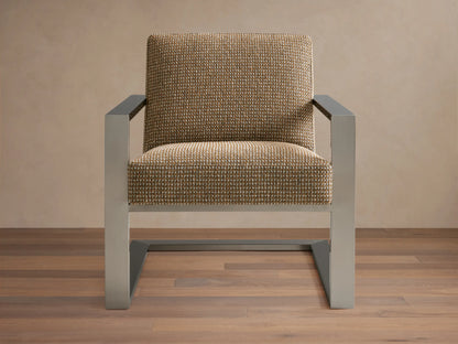 Sabina Chair with a textured beige upholstered seat and backrest, supported by sleek metallic angular legs on a wooden floor.