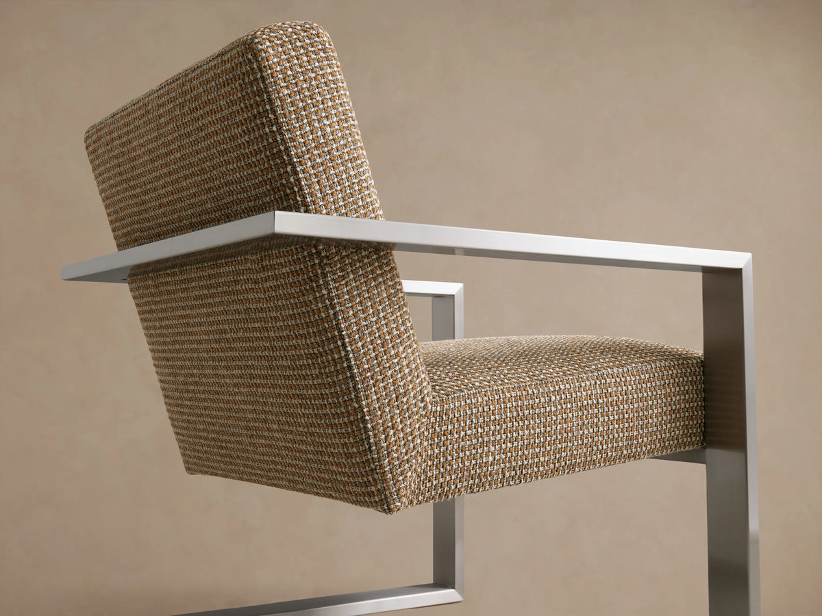 Sabina Chair with textured beige fabric and sleek metal frame, front view on wooden floor against a neutral wall.