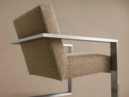 Sabina Chair with textured beige fabric and sleek metal frame, front view on wooden floor against a neutral wall.