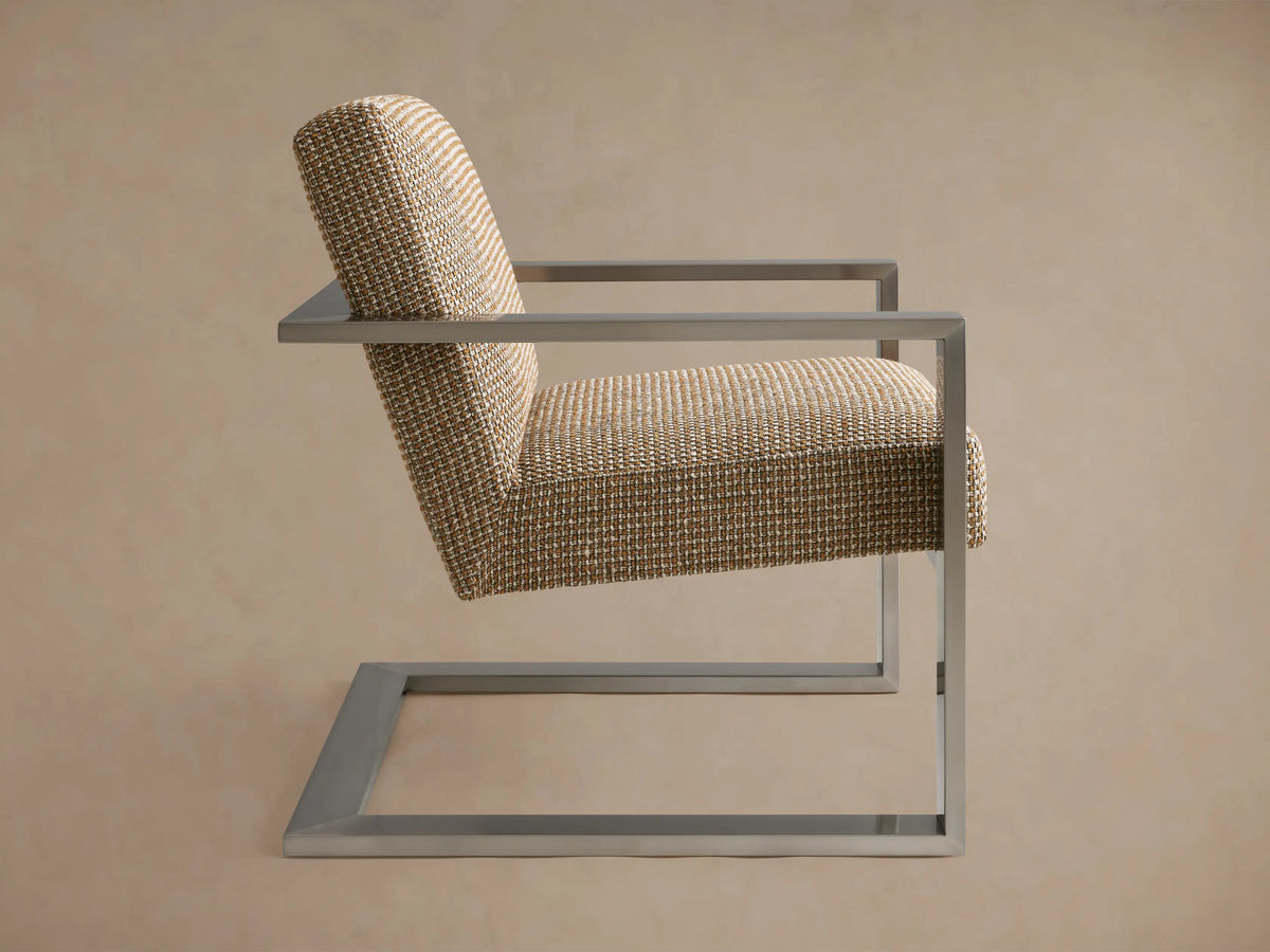 A contemporary Sabina Chair with a modern design, featuring a woven fabric seat and backrest supported by a sleek, metallic frame.