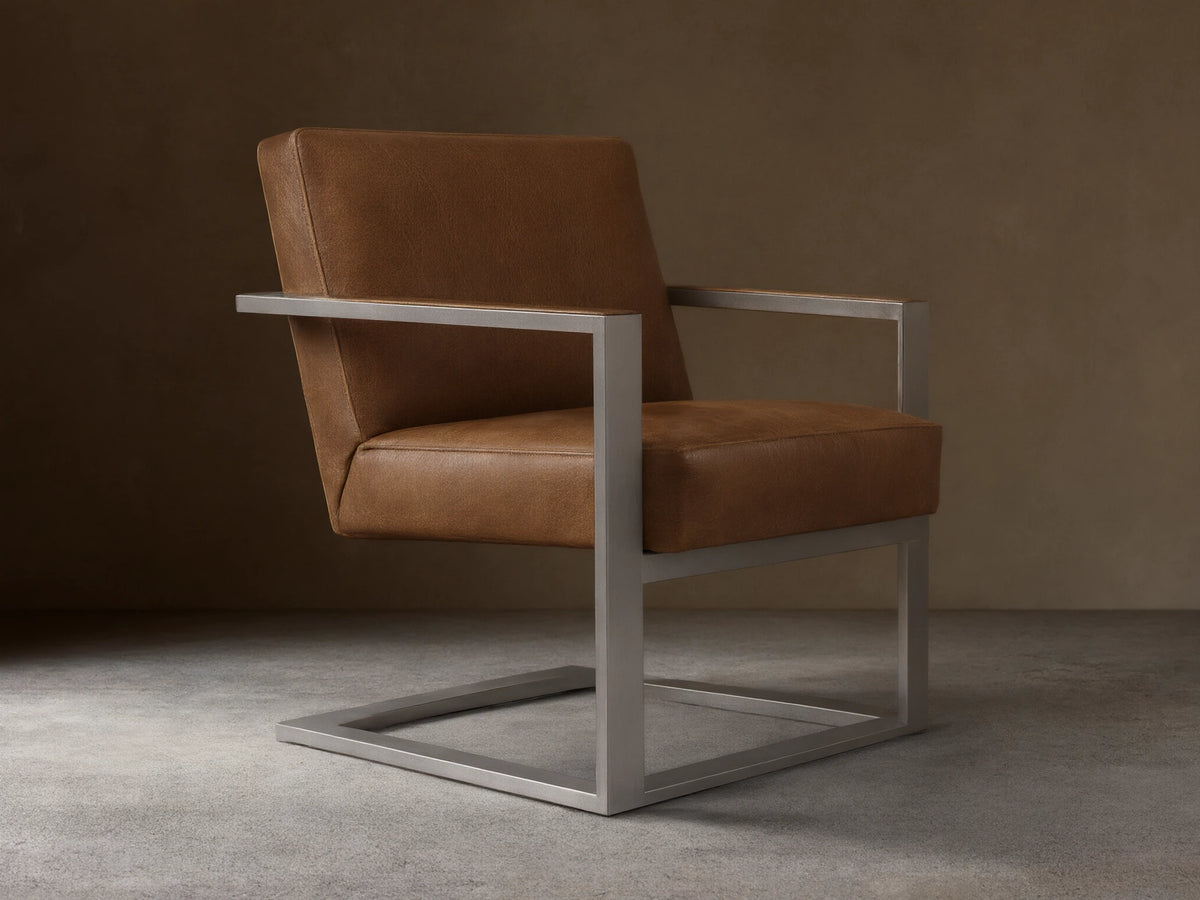 Front view of the brown Sabina Leather Chair, with rich brown leather cushions and a brushed silver-toned steel frame.