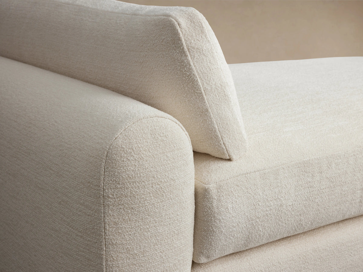 Sloane Daybed in cream-colored fabric with plush seat and back cushions, featuring a modern rectangular design against a neutral background.