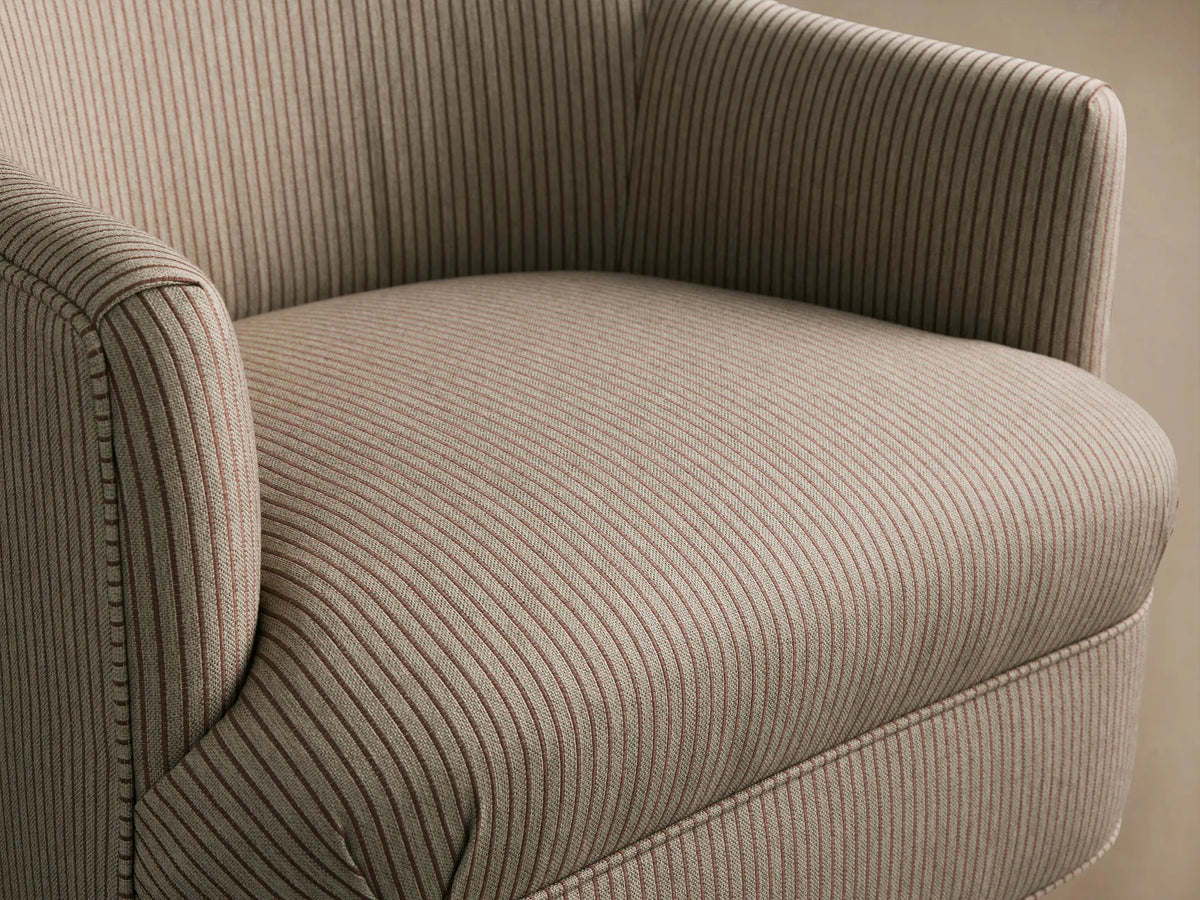 Savannah upholstered armchair in light beige fabric with fine dark vertical stripes, curved arms, nailhead trim, and dark wooden tapered legs.