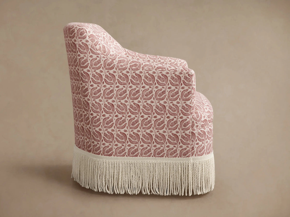 Back and side view of Savannah Swivel Chair. Cream fabric with red botanical paisley pattern, long cream fringe trim.