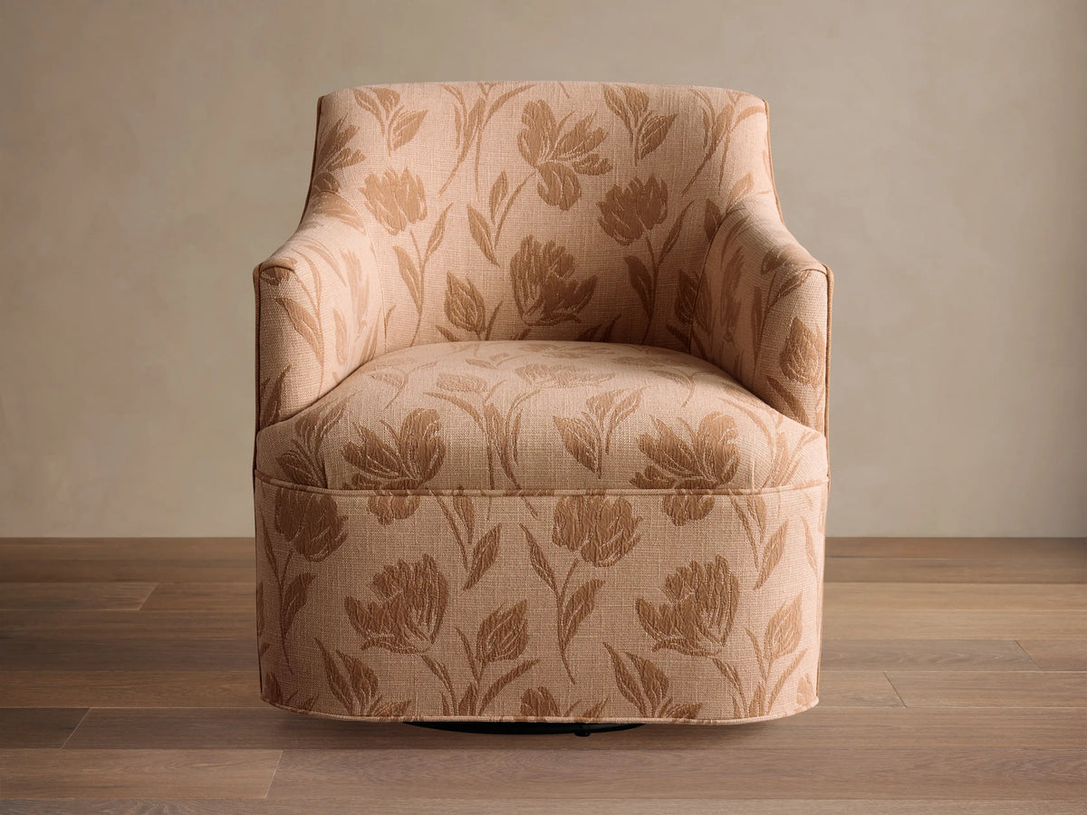 Savannah Swivel Chair in beige fabric with tan floral pattern, angled on wooden floor against neutral wall.