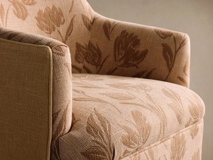 Savannah Swivel Chair, peach fabric with dark brown floral pattern, front view on wood floor.