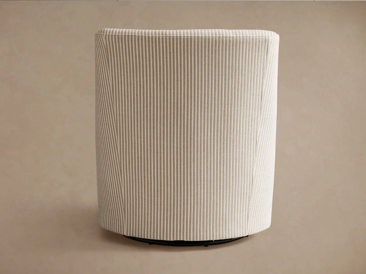 Savannah Swivel Chair, seen from back-left. Light beige fabric with vertical grey pinstripes and dark swivel base.