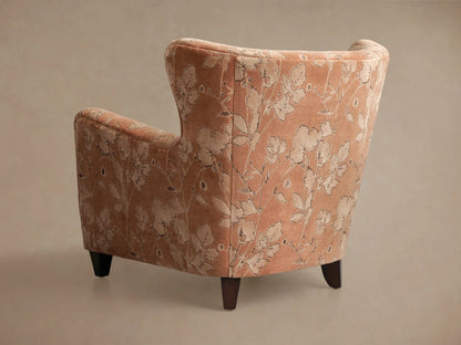 Close-up of the peach Sasha Chair armrest, featuring raised light floral patterns with dark outlines.