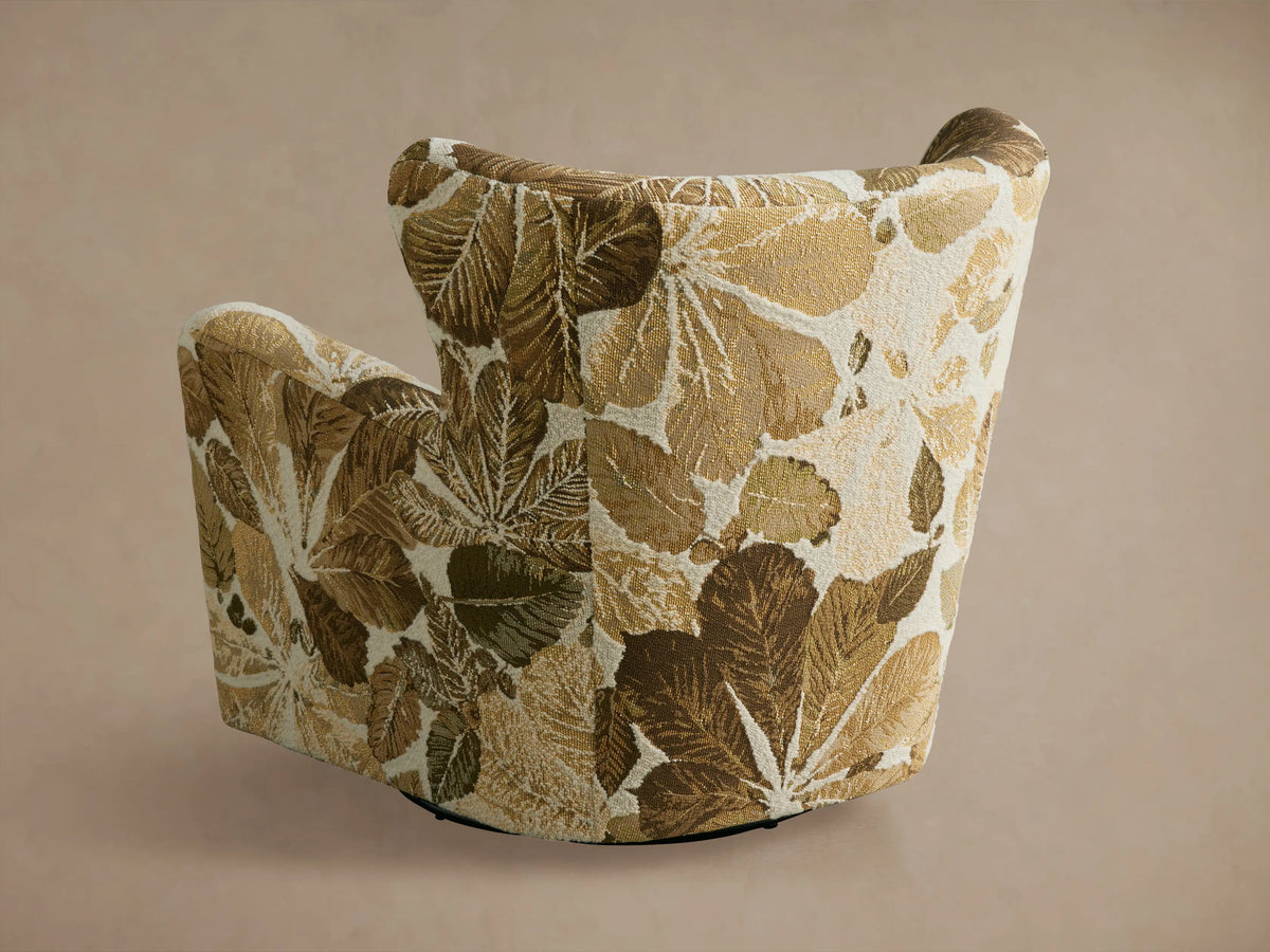 Sasha Swivel Chair featuring a botanical leaf pattern in shades of green and tan on a neutral background, viewed from the side.