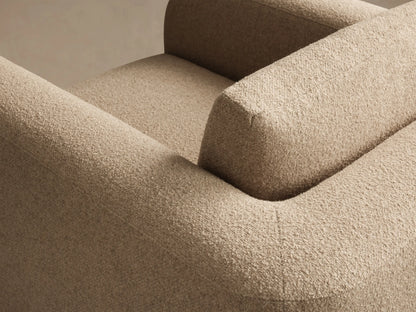 Rear view of the light beige textured Stiles Chair, featuring a modern, rounded design and a distinct back cushion.