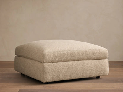 Close-up of the Beige Stiles Ottoman, highlighting its soft, nubbly textured fabric and visible corner seam.