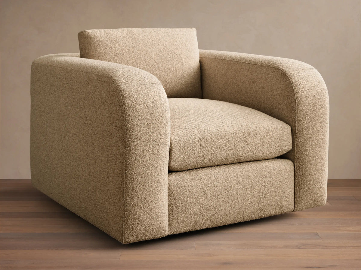 Front view of a beige Stiles Swivel Chair with rounded arms, a loose back cushion, and textured upholstery.
