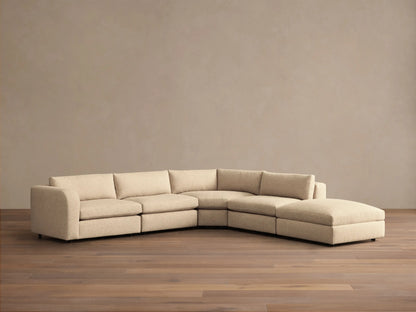 Front view of the cream Stiles Five-Piece Sectional, an L-shaped modular sofa featuring a corner, three seats, and an ottoman.