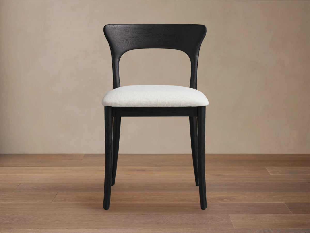 Dark stained oak Sinclair Dining Chair with a curved back and light upholstered seat at a round dining table.