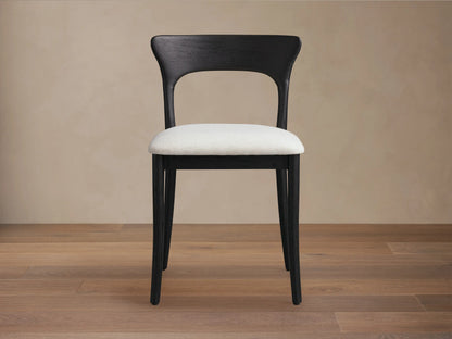 Dark stained oak Sinclair Dining Chair with a curved back and light upholstered seat at a round dining table.