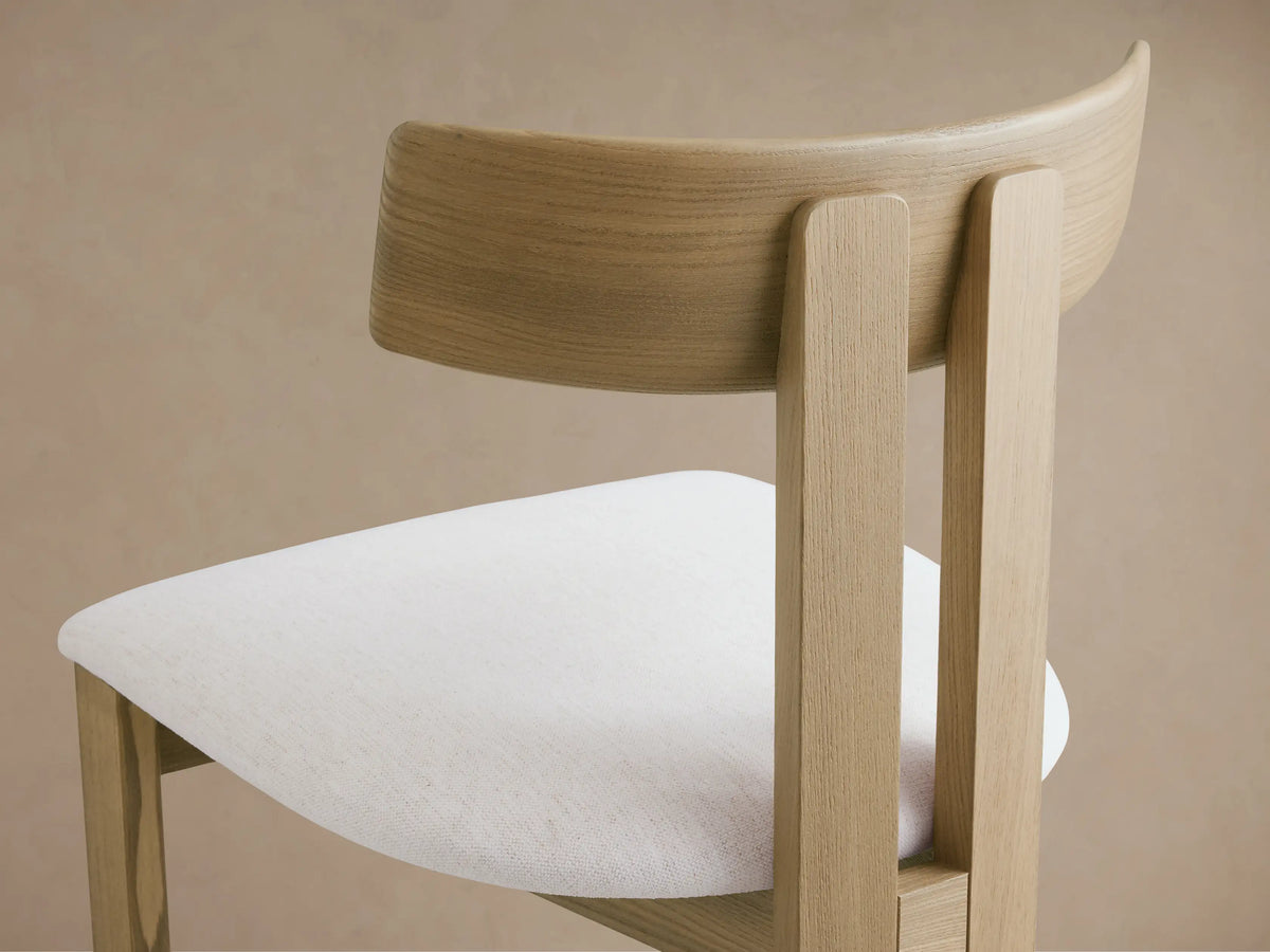 Rodin Wood Back Dining Chair with a light ash wood frame, curved backrest, and a white upholstered seat, front view.