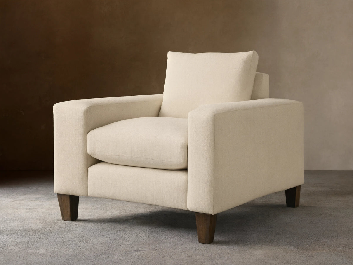 Cream Kipton Wide Arm Elevated Chair, angled front-right, featuring wide arms, plush cushions, and rich mocha wooden feet.