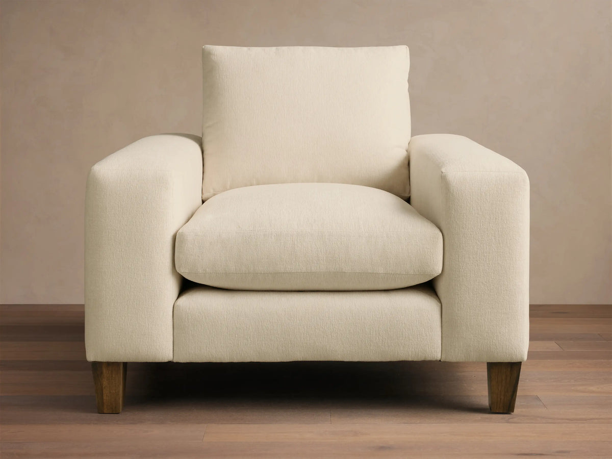 Cream Kipton Wide Arm Elevated Chair, angled front-right, featuring wide arms, plush cushions, and rich mocha wooden feet.