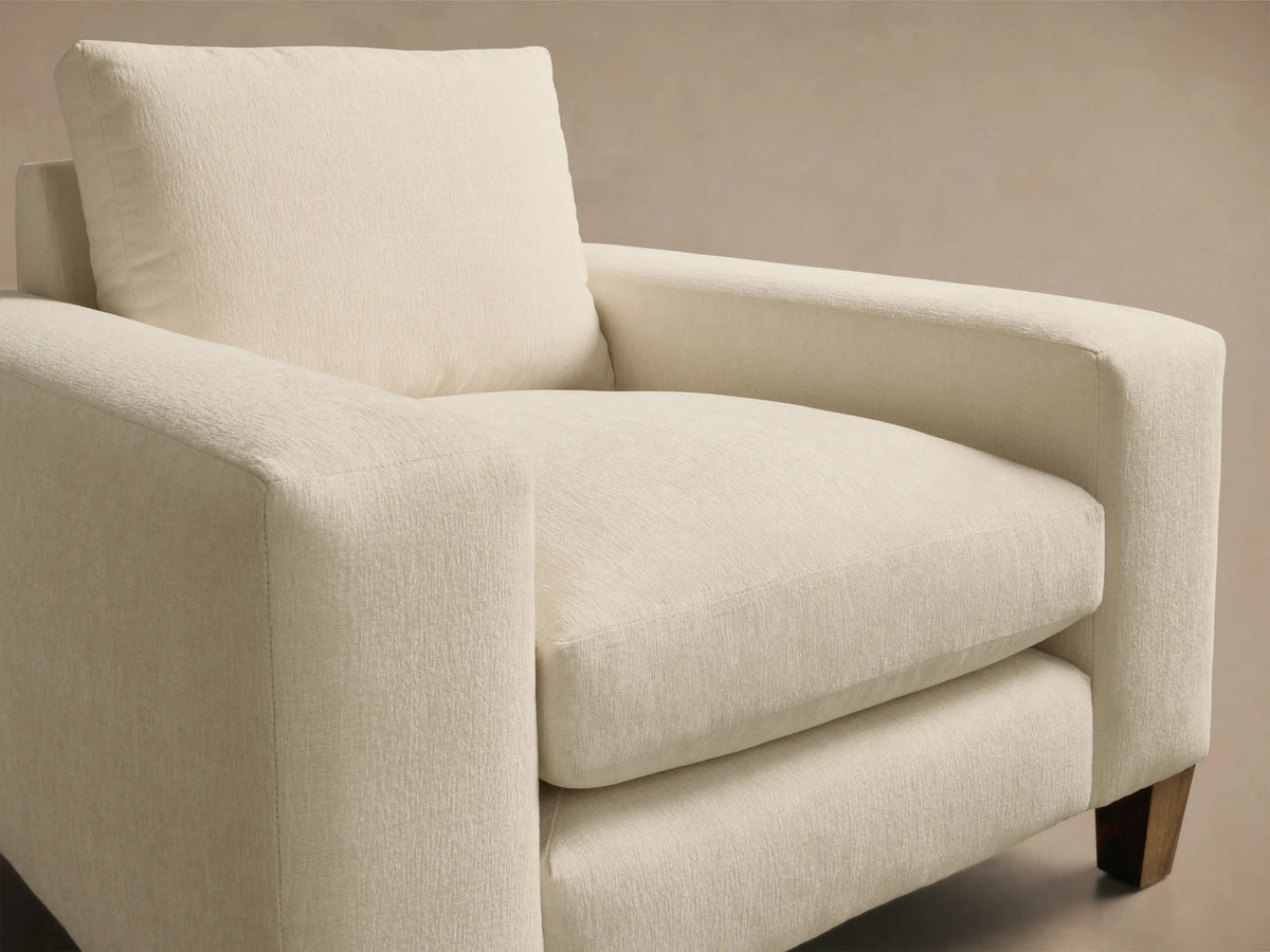 Front view of the off-white Kipton Wide Arm Elevated Chair with plush cushions and mocha finish feet.