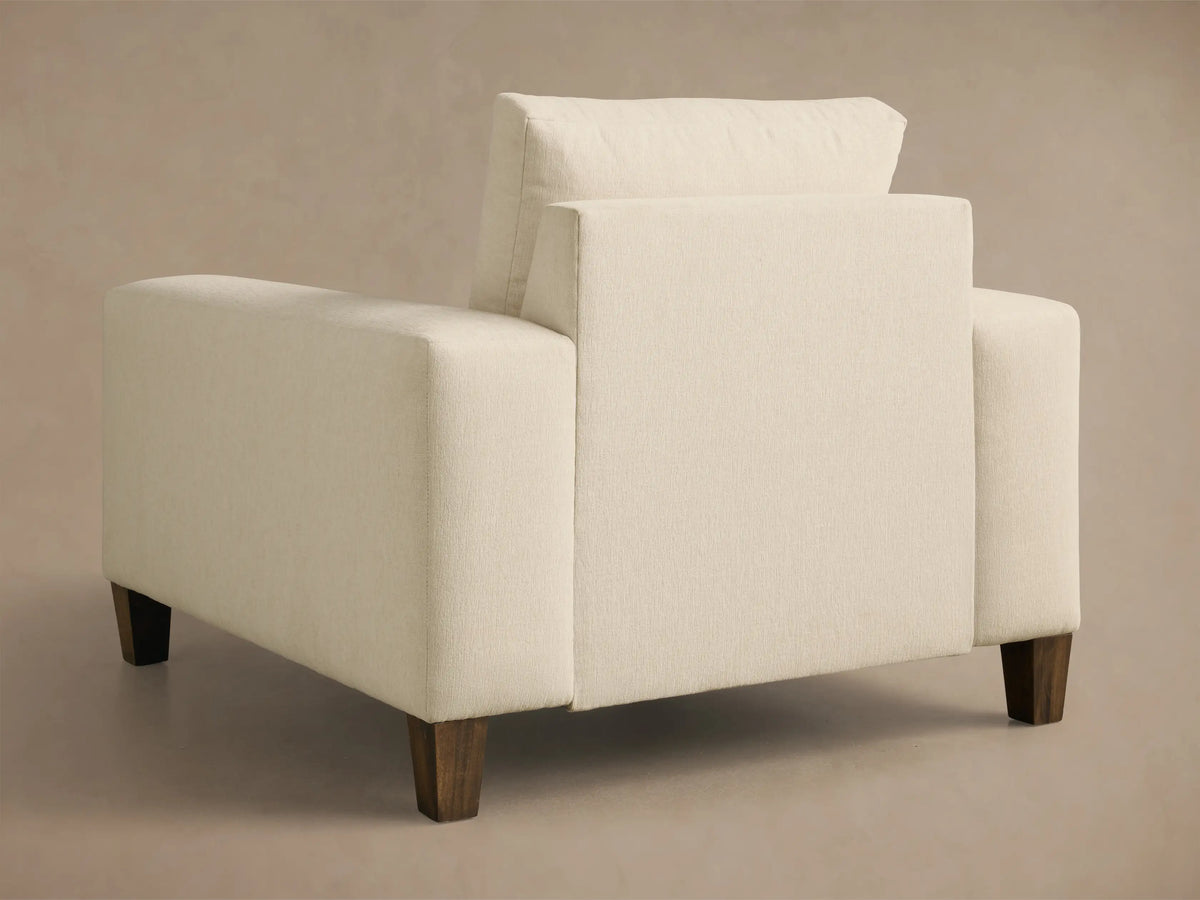 Front 3/4 view of the Cream Kipton Wide Arm Elevated Chair, showing wide arms, plush cushions, and a mocha-finished foot.
