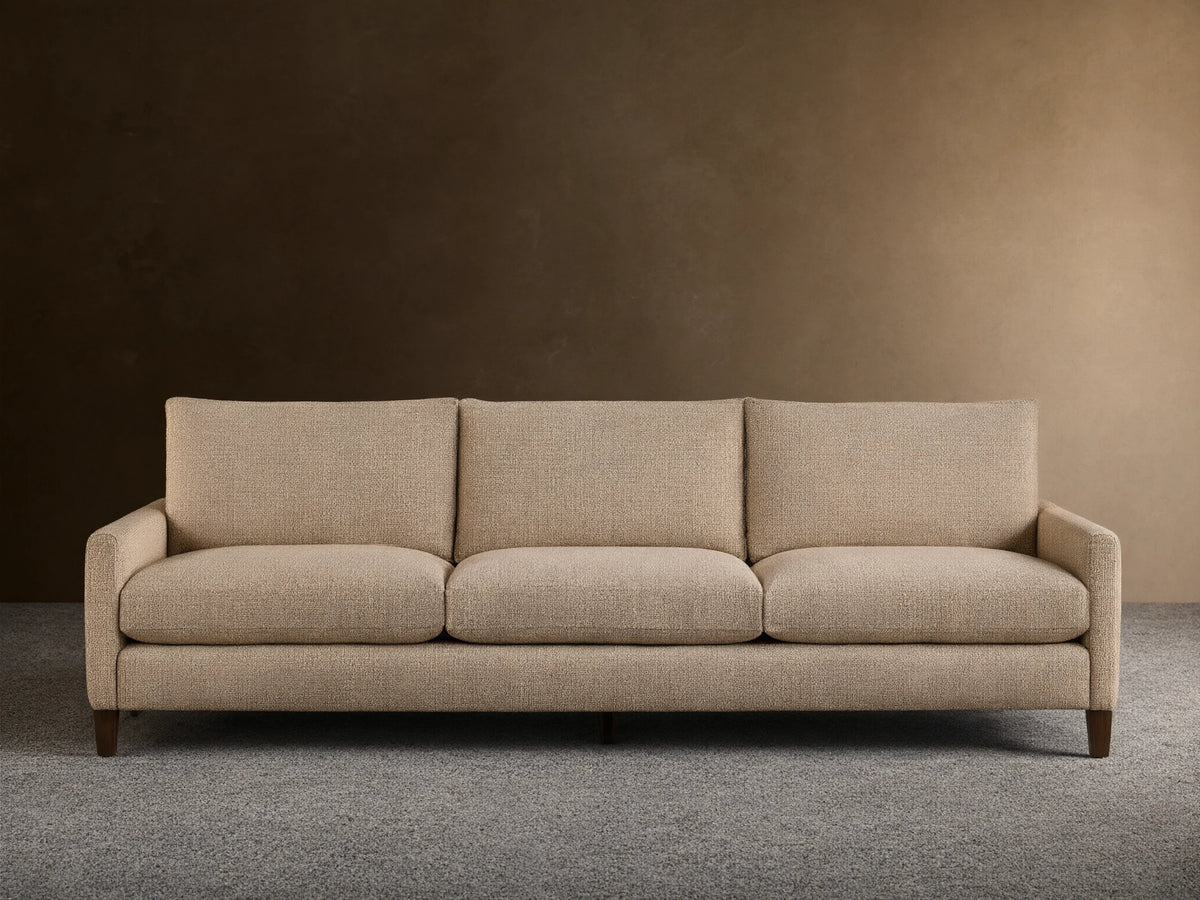 Front view of the light beige Kipton Slim Arm Elevated Three-Cushion Sofa with slim arms and dark wood feet.
