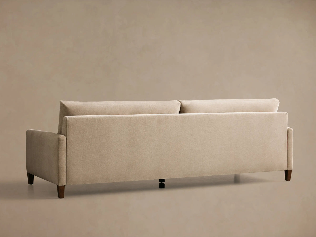 Front view of a beige Kipton Slim Arm Elevated Sofa with slim arms and dark mocha finish feet.