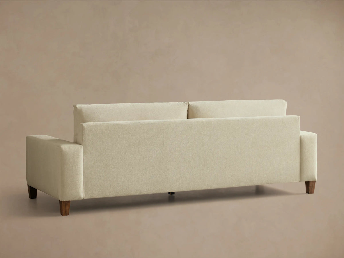 Close-up of the wide armrest of the beige textured Kipton Wide Arm Elevated Sofa, showing part of the backrest.