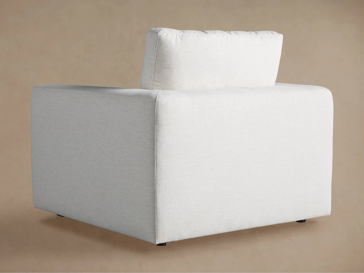 Light beige upholstered back cushion and armrest of the Beale Chair, showing textured fabric against a soft brown background.