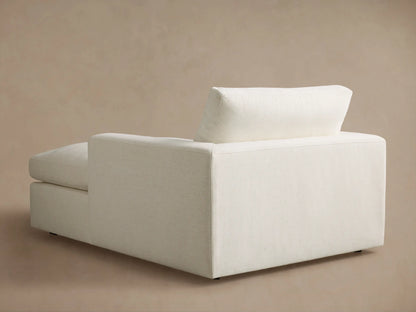 Close-up of the cream textured fabric armrest and seat of a furniture piece, showing detailed stitching.