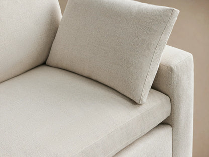 Beale Sofa: Casual light cream 2-seater sofa with block arms, loose back cushions, & one throw pillow on wood floor.