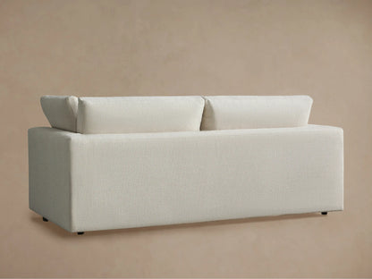 Close-up of Beale Sofa's light cream, textured fabric seat cushion, back cushion, and armrest against a soft beige wall.