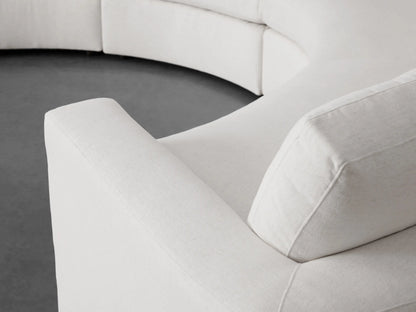 Beale Four-Piece Curved Sectional in off-white fabric, showing its gentle curve and soft cushions against a minimalist gray background.